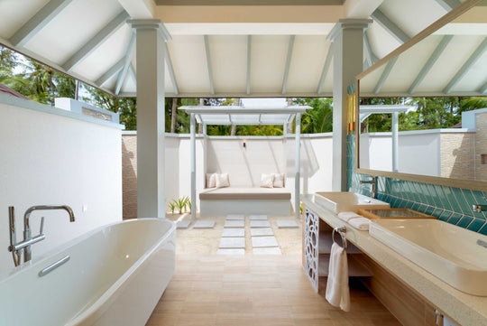 Sun Siyam Olhuveli, South Malé Atoll — suite bathroom with a bath, a daybed and the garden beyond