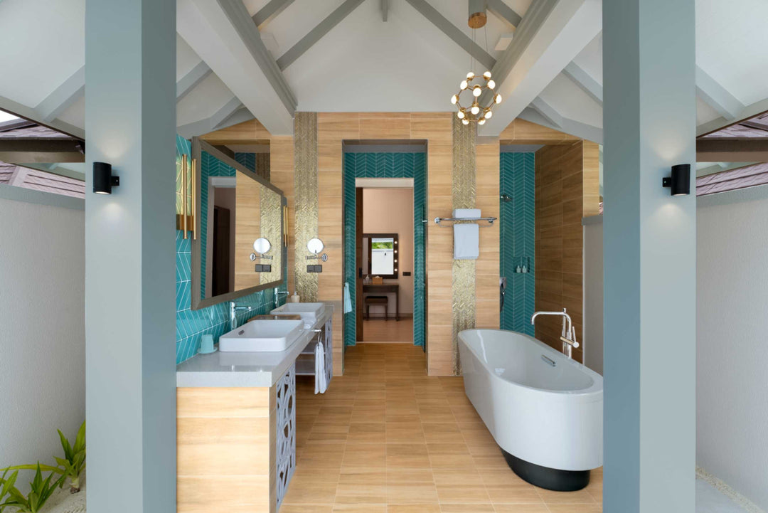 Sun Siyam Olhuveli, South Malé Atoll — suite bathroom with turquoise tiling, twin basins and a freestanding bath
