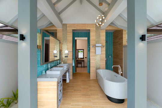 Sun Siyam Olhuveli, South Malé Atoll — suite bathroom with turquoise tiling, twin basins and a freestanding bath