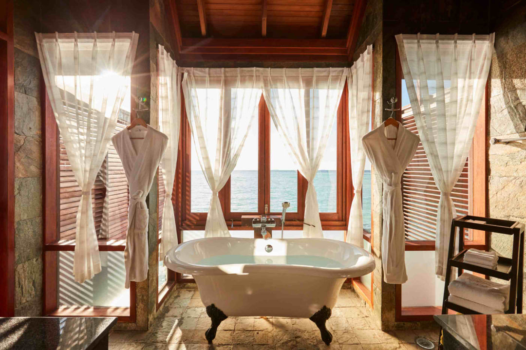 Sun Siyam Olhuveli, South Malé Atoll — clawfoot bath in front of shuttered windows over the water