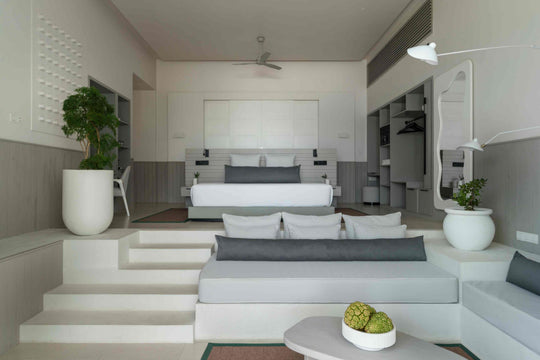 Sun Siyam Iru Veli, Dhaalu Atoll — bedroom with grey wall panelling, the bed on a raised platform and a mirror beside the wardrobe