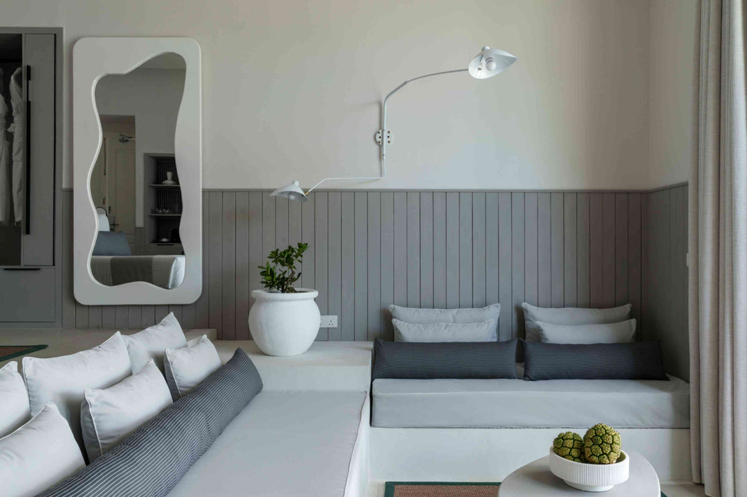 Sun Siyam Iru Veli, Dhaalu Atoll — seating alcove with a built-in bench and cushions, a wavy mirror and a wall lamp