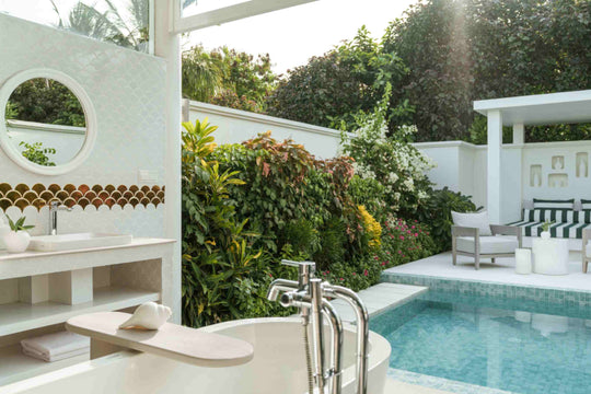 Sun Siyam Iru Veli, Dhaalu Atoll — open-air bathroom with a round window, basin and tub beside the private pool