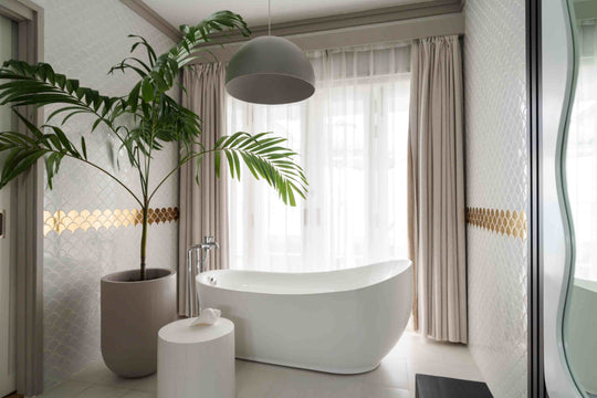 Sun Siyam Iru Veli, Dhaalu Atoll — bathroom with a freestanding tub, a potted palm and a gold tile band