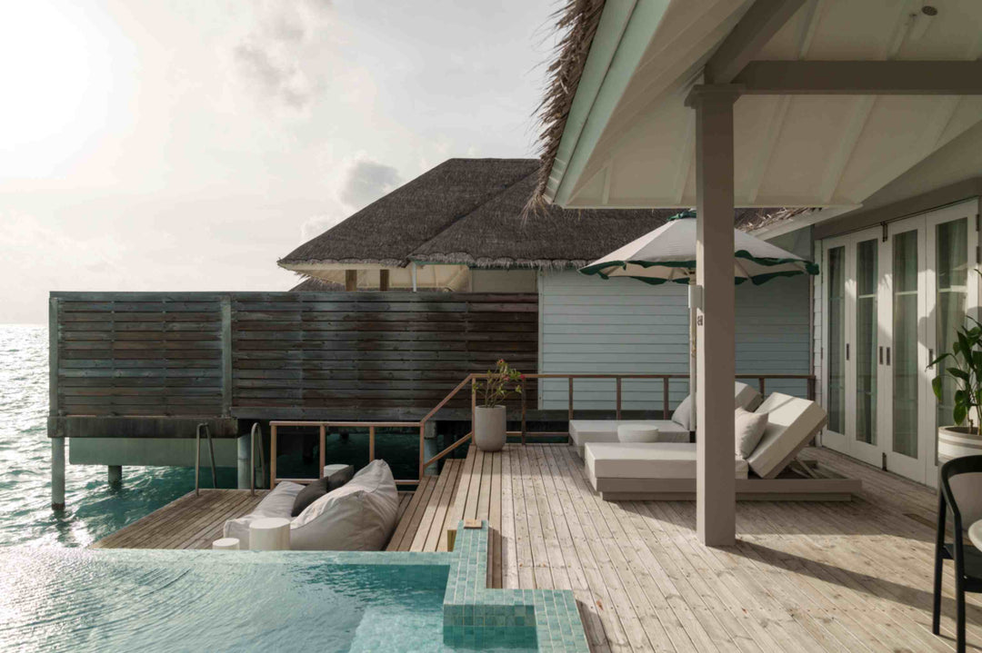 Sun Siyam Iru Veli, Dhaalu Atoll — overwater villa exterior, thatched roof over a deck with a daybed and pool