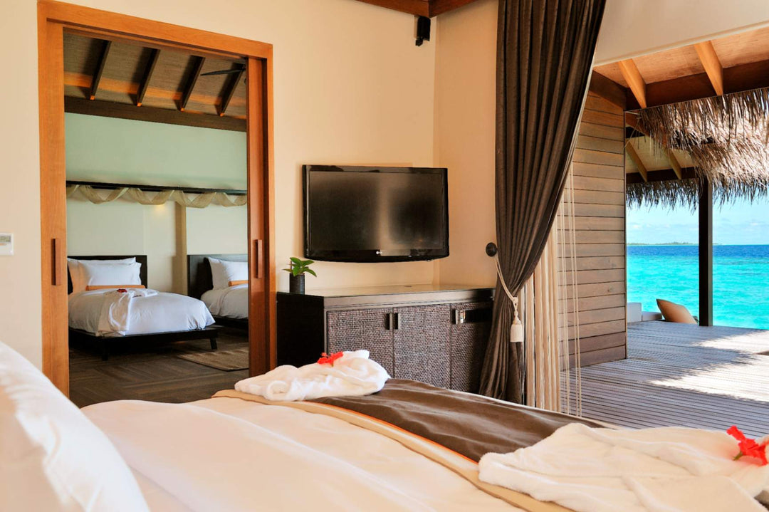 A lagoon suite bedroom at Ayada Maldives with the turquoise water framed in the doorway