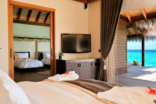 A lagoon suite bedroom at Ayada Maldives with the turquoise water framed in the doorway