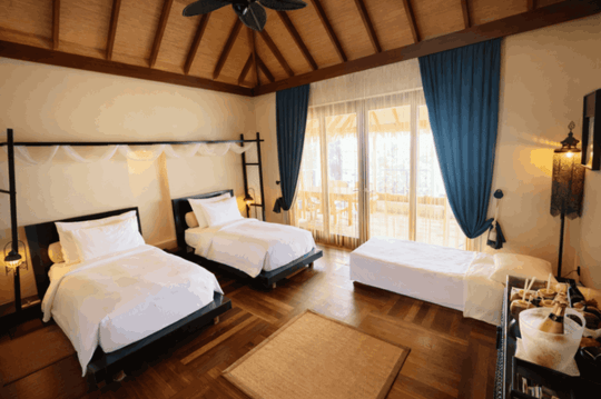 The second bedroom of a family lagoon suite at Ayada Maldives, made up with twin beds