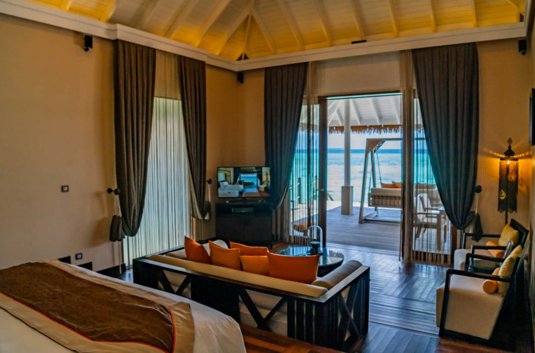 A lagoon suite living room at Ayada Maldives, orange sofa facing the open doors