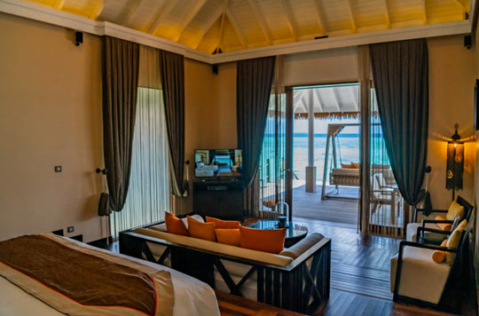 A lagoon suite living room at Ayada Maldives, orange sofa facing the open doors