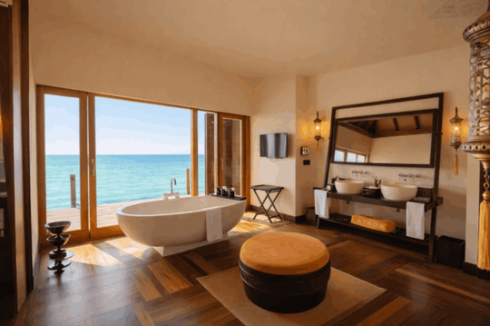 A sunset ocean suite bathroom at Ayada Maldives with a tub and views out to the water