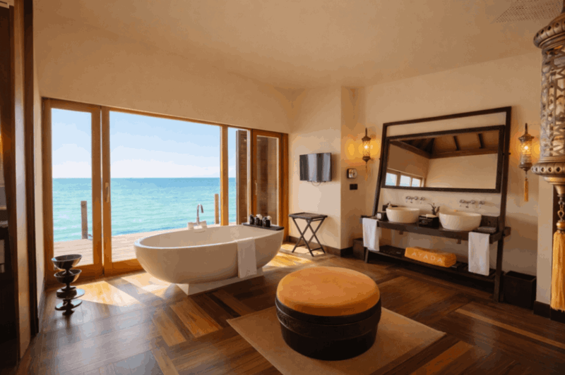 A sunset ocean suite bathroom at Ayada Maldives with a tub and views out to the water