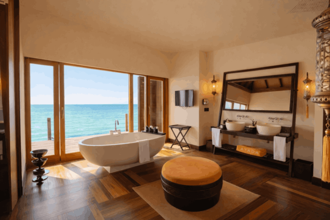 A suite bathroom at Ayada Maldives with twin basins and a tub by the window