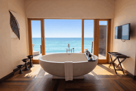 A freestanding tub at Ayada Maldives set by a window looking over the lagoon