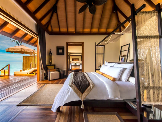 A suite bedroom at Ayada Maldives under a high timber ceiling
