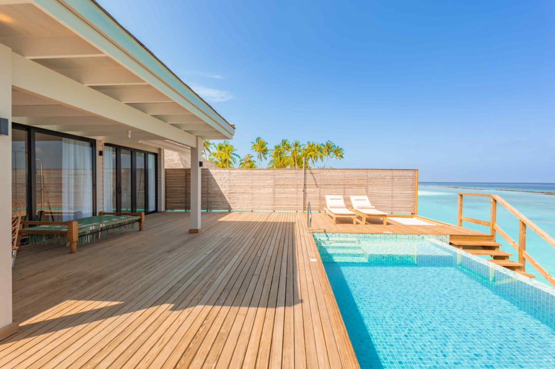 Sun loungers on the deck of an overwater villa at ananea Madivaru Maldives, the private pool with steps down to the lagoon
