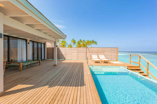 Sun loungers on the deck of an overwater villa at ananea Madivaru Maldives, the private pool with steps down to the lagoon