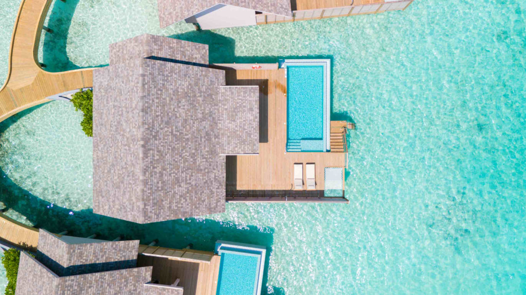 An overwater villa at ananea Madivaru Maldives from directly above, its pool and deck set over pale turquoise water
