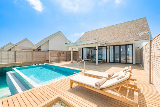 The pool and sun loungers on the deck of a villa at ananea Madivaru Maldives, the villa behind