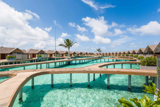 The overwater walkway at ananea Madivaru Maldives curving between the villas and the lagoon