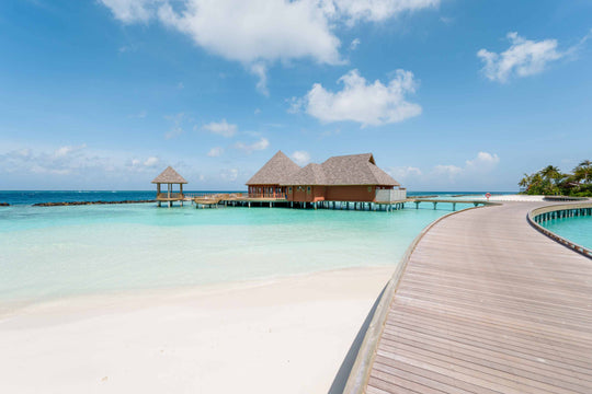 The overwater restaurant at ananea Madivaru Maldives seen from the timber jetty crossing the lagoon