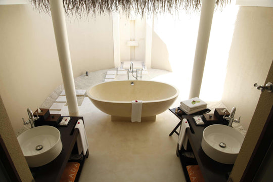 A garden villa bathroom at Ayada Maldives with a freestanding tub between two basins