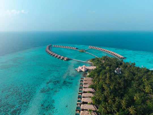 Ayada Maldives from a distance, the overwater villas a thin line on the pale lagoon