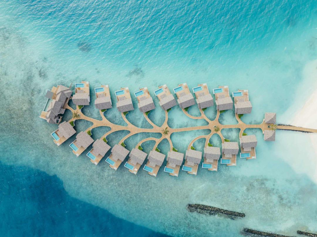 The overwater villas at ananea Madivaru Maldives from high above, ranged in two rows along a central jetty