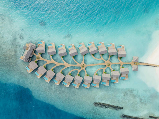 The overwater villas at ananea Madivaru Maldives from high above, ranged in two rows along a central jetty