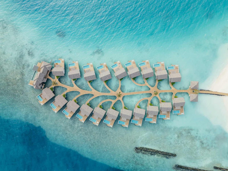 The overwater villas at ananea Madivaru Maldives from high above, ranged in two rows along a central jetty