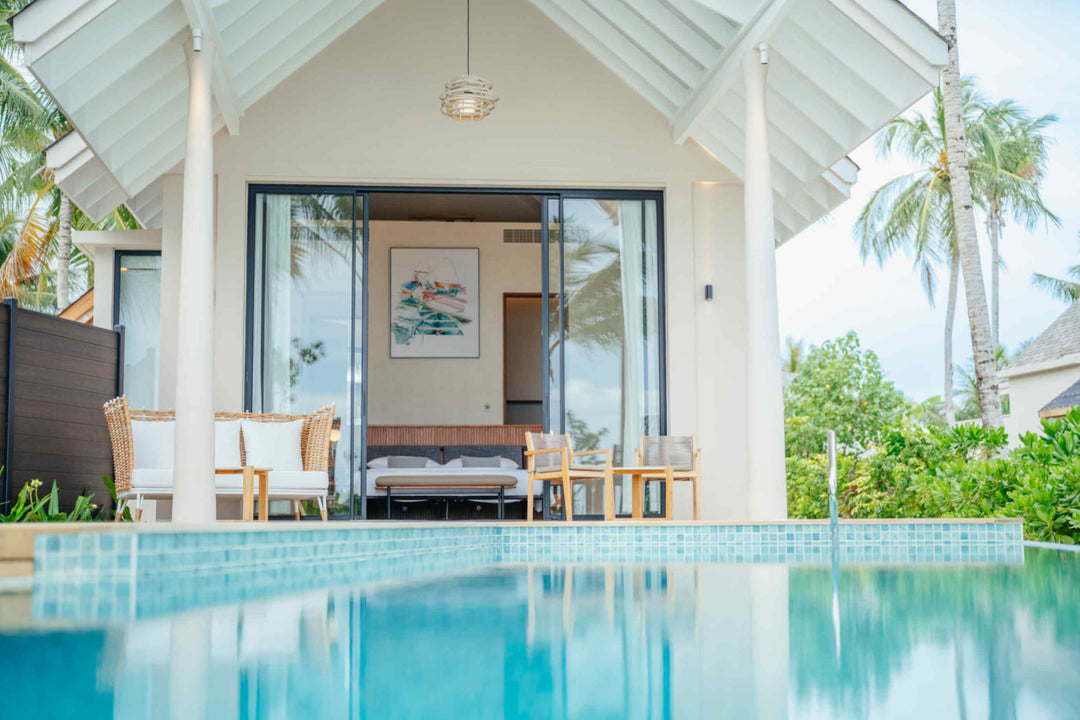 A villa at ananea Madivaru Maldives seen across the pool, the sitting area open to the terrace