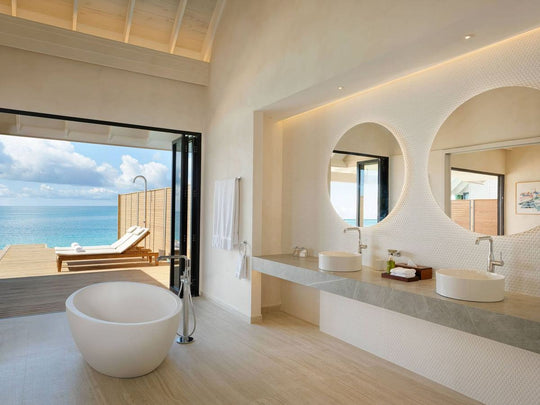 The bathroom of a Water Pool Villa at ananea Madivaru Maldives, twin basins with the lagoon through the open doors