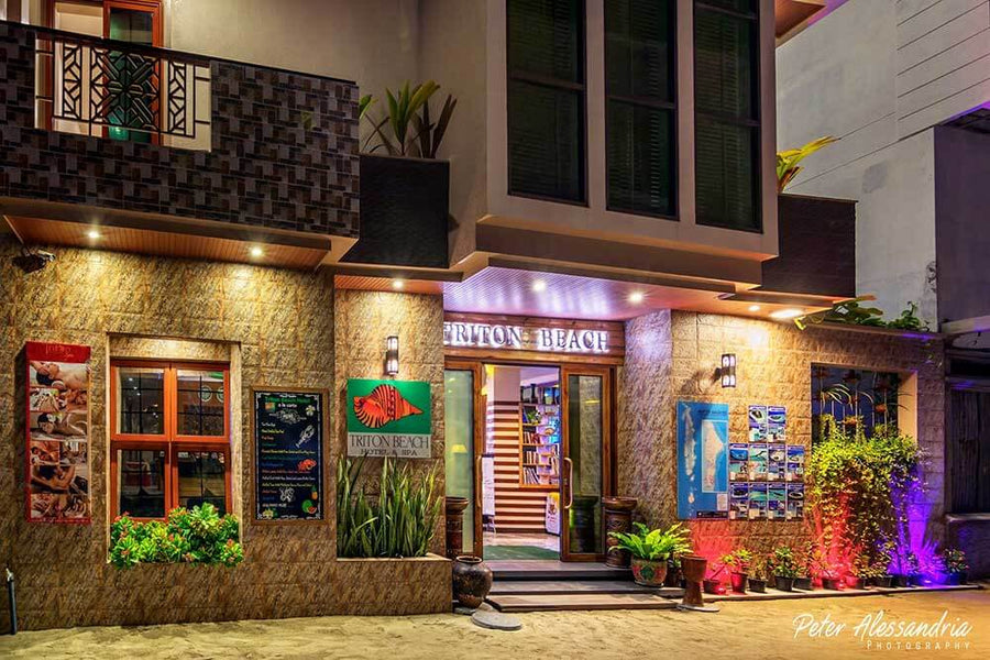 Entrance of Triton Beach Hotel & Spa on Maafushi, lit up in the evening