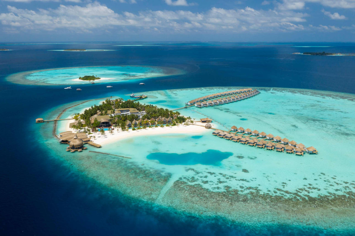 OUTRIGGER Maldives Maafushivaru Resort from the air, the small island and its sandbank ringed by deep blue water