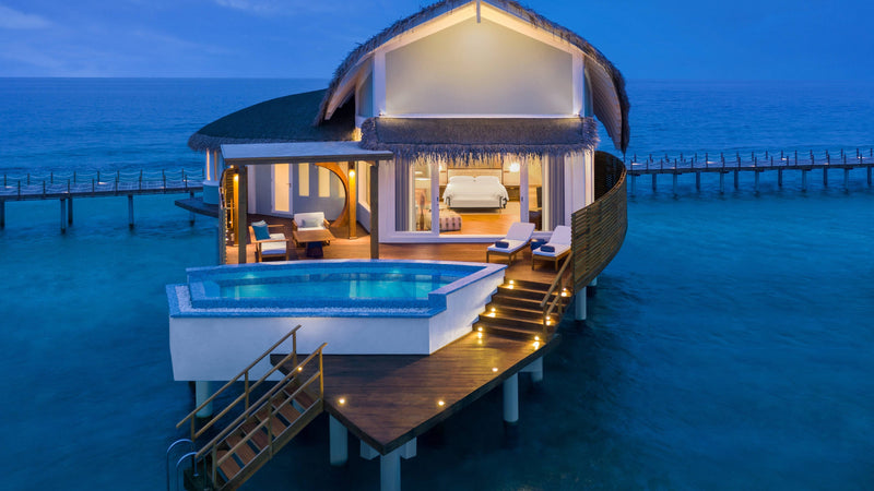 An Overwater Pool Villa at JW Marriott Maldives Resort & Spa, seen from outside at twilight