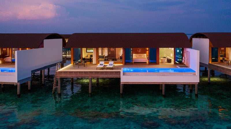 An Overwater Villa with Pool at The Westin Maldives Miriandhoo Resort, seen from outside at twilight