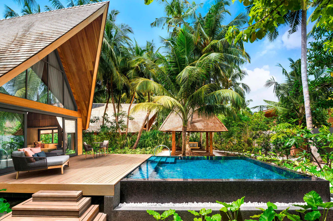 The St. Regis Maldives Vommuli, Dhaalu Atoll — Villa pavilion set in dense greenery, with a dark-tiled pool and a sun deck