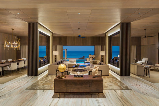 The St. Regis Maldives Vommuli, Dhaalu Atoll — Living room with pale timber floors and sea views on two sides, dining area beyond