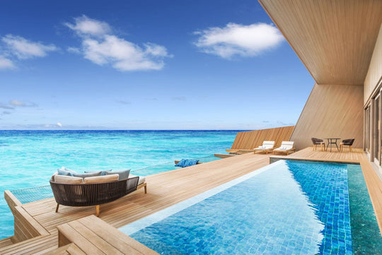 The St. Regis Maldives Vommuli, Dhaalu Atoll — Overwater deck with an infinity pool and a hanging daybed above the lagoon