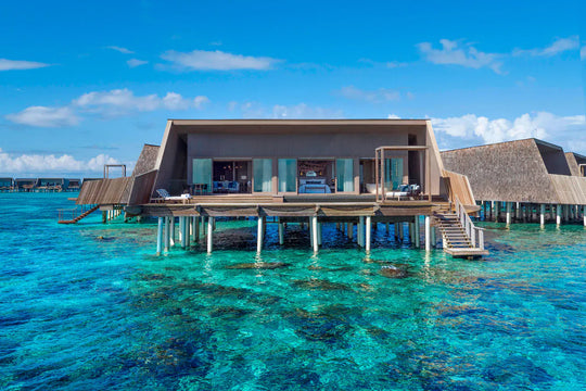The St. Regis Maldives Vommuli, Dhaalu Atoll — Overwater suite on stilts above the coral, seen from the lagoon