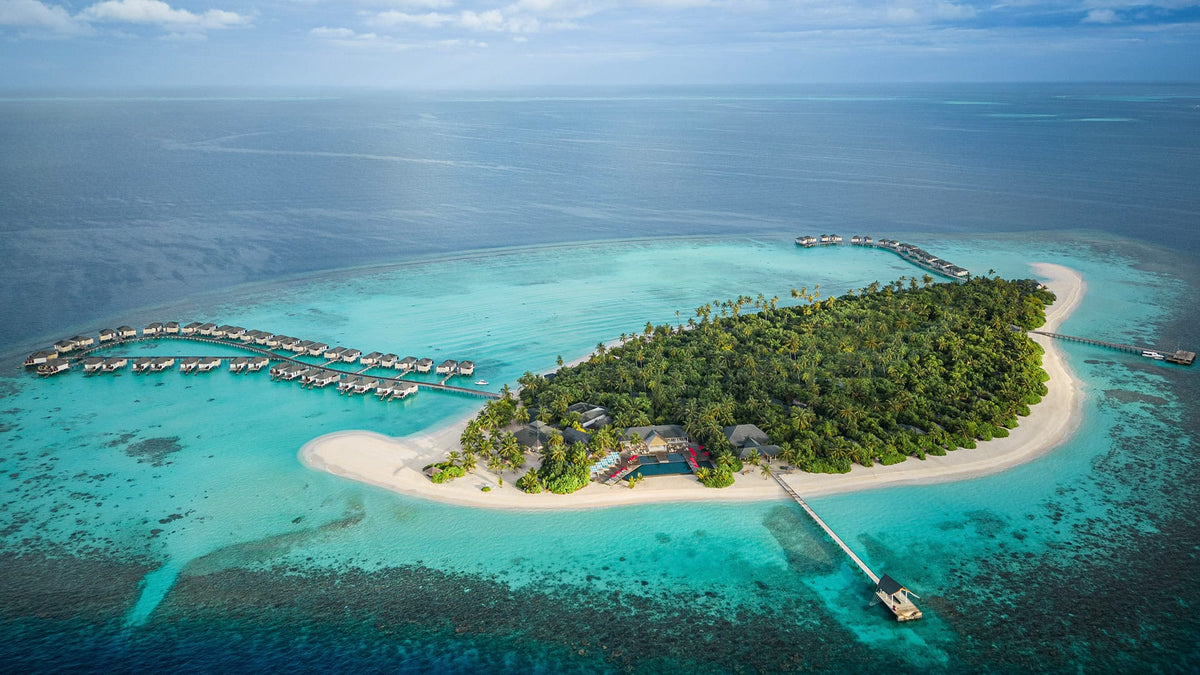 NH Collection Maldives Havodda Resort from the air, the island and its overwater villas.