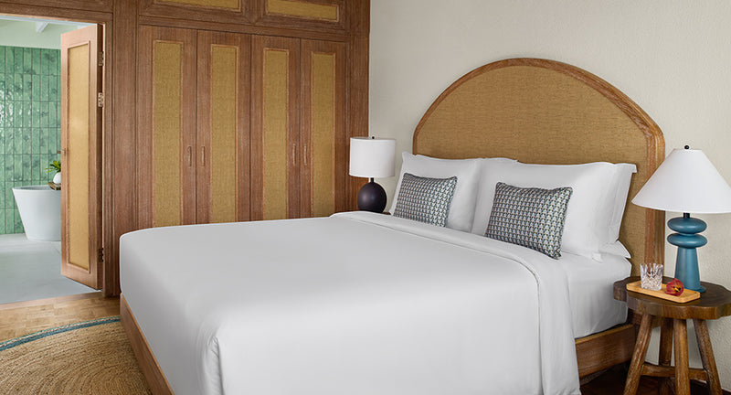 The bed in a Sunset Beach Villa at NH Collection Maldives Reethi Resort.