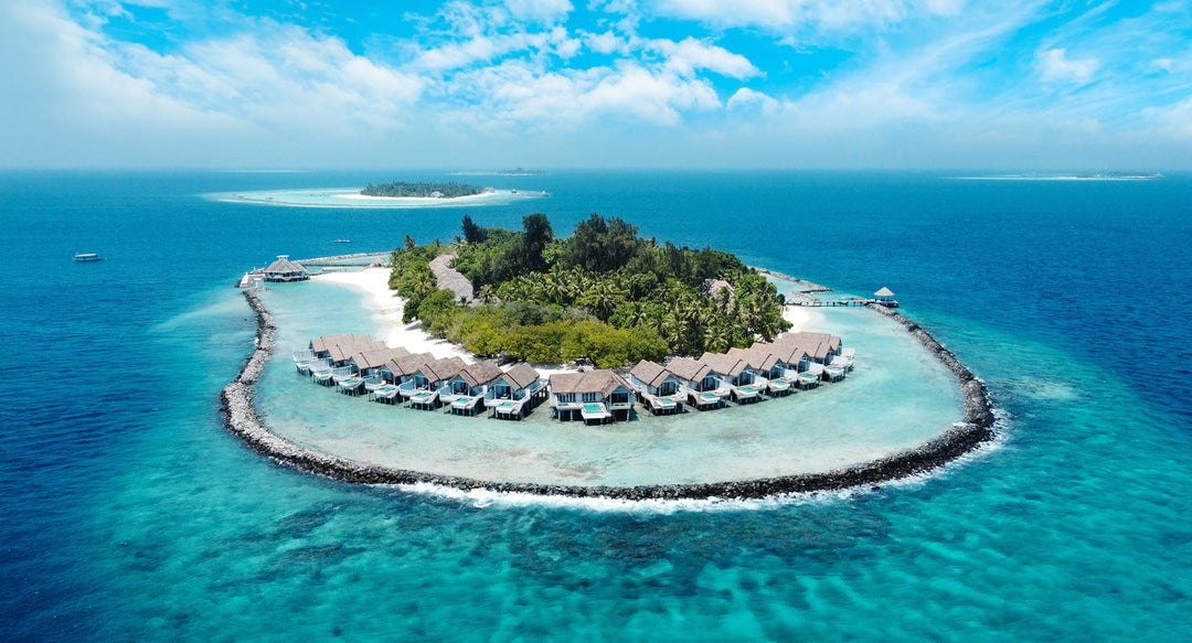 NH Maldives Kuda Rah Resort, South Ari Atoll — aerial of the island with overwater villas around its edge