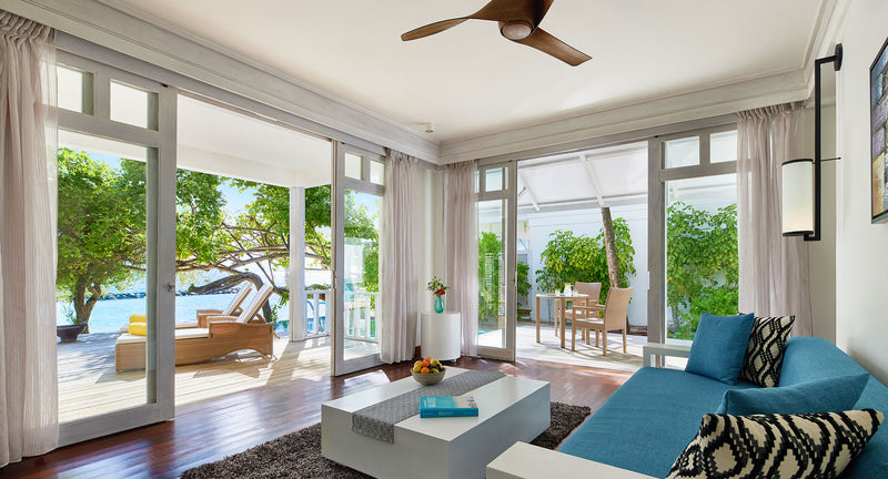 NH Maldives Kuda Rah Resort, South Ari Atoll: the living room of a One Bedroom Beach Pool Pavilion Suite, opening onto a shaded garden terrace.
