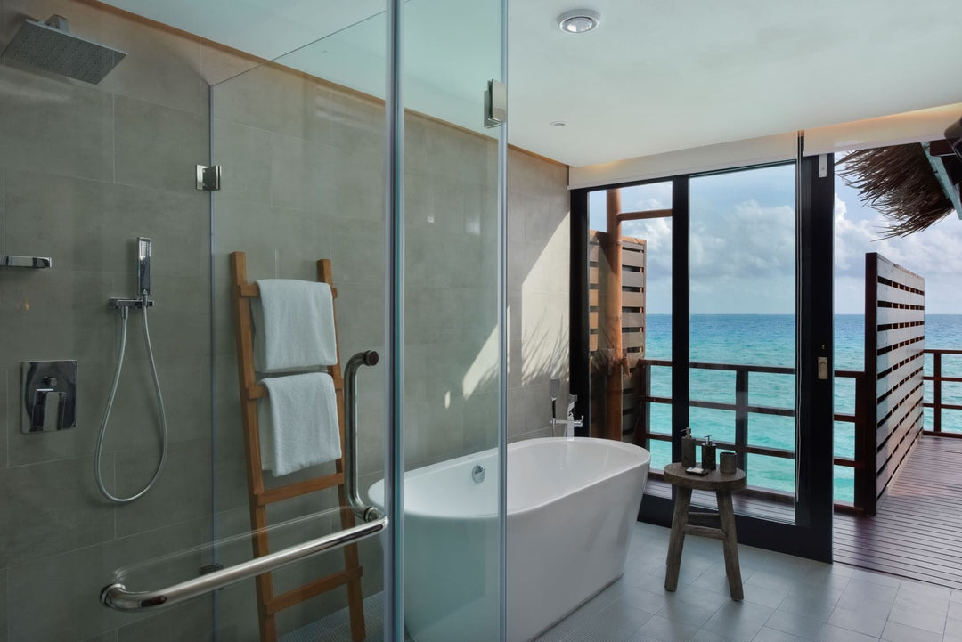 An Ocean Water Villa bathroom at Grand Park Kodhipparu, a bathtub beside a window onto the ocean