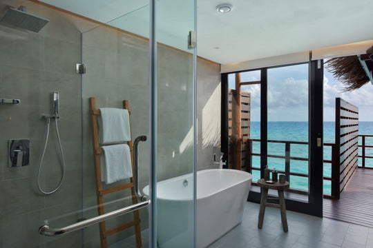 An Ocean Water Villa bathroom at Grand Park Kodhipparu, a bathtub beside a window onto the ocean