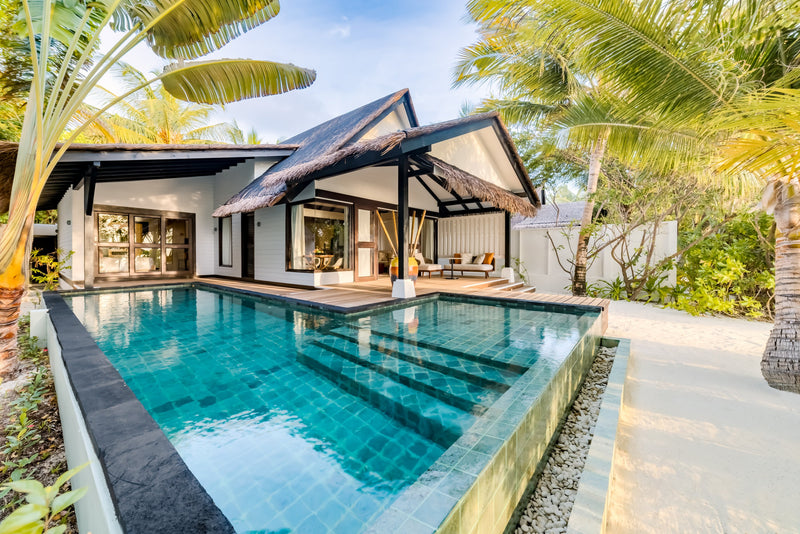 The long private pool in front of a two-bedroom Earth Pool Pavilion at OZEN LIFE Maadhoo, the thatched pavilion and palms behind