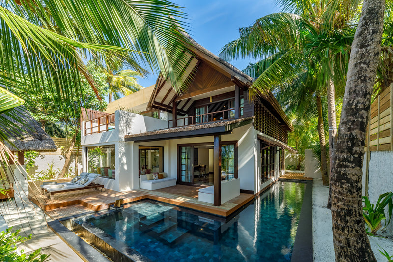 A two-bedroom Earth Pool RESERVE at OZEN RESERVE BOLIFUSHI, a two-storey beach villa with a long tiled pool and sun deck under the palms