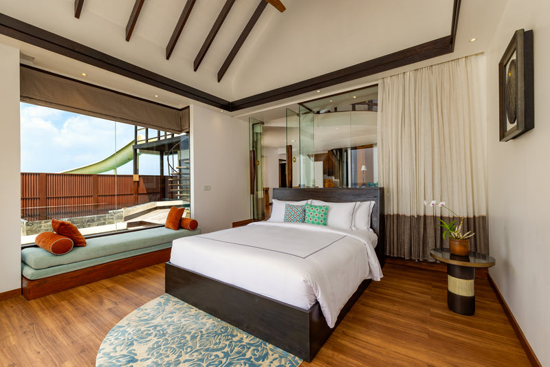 The second bedroom of a two-bedroom Ocean Pool RESERVE Sunset with Slide at OZEN RESERVE BOLIFUSHI, a double bed and window seat with the slide visible outside