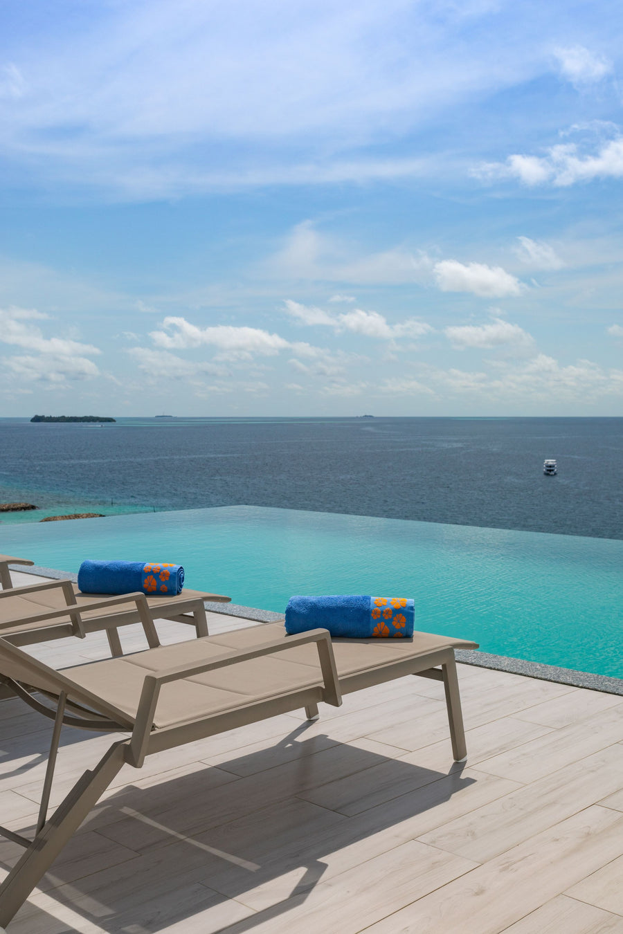 Infinity pool with sun loungers looking out over the sea at Kaani Palm Beach